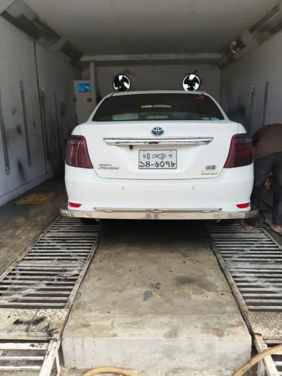 White sedan inside the paint booth.